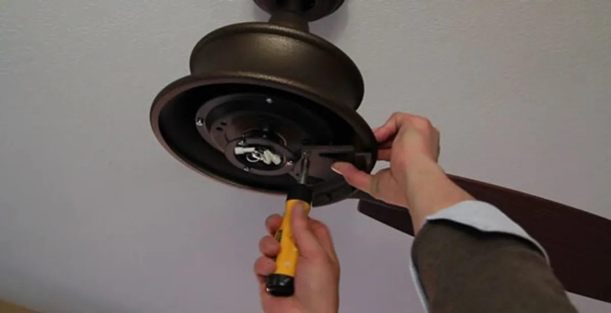 Electrician installing ceiling fan mounting bracket and fixture in Sarasota, FL